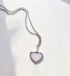 A pale pink small heart necklace made with the stained glass method. I use lead free solder containing primarily tin and silver. And it hangs by a stainless steel chain. The necklace length is customizable if you have a preference! White Metal Heart Necklace With Heart Charm, White Metal Heart Necklace Gift, White Heart-shaped Hypoallergenic Necklace, Hypoallergenic White Heart Necklace, White Heart-shaped Nickel-free Charm Necklace, Nickel-free White Charm Necklace For Valentine's Day, Nickel-free White Heart Pendant Necklace, White Nickel-free Heart Pendant Necklace, Nickel-free Heart-shaped White Necklace