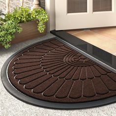 a brown door mat sitting next to a potted plant