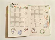 an open planner book with drawings on the pages and decorations around it, sitting on a white surface