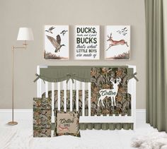 a baby crib with two deer prints on the wall and a lamp next to it