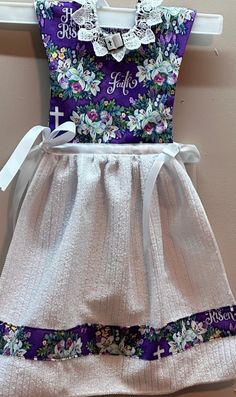 This hanging kitchen towel is made to resemble a dress! The top is purple with flowers with the words faith. rejoice, and He is risen.  There is white lace and a bible button at the neck.   The bottom is white whit a strip of the purple material across the bottom. The top measures 7 inches from shoulder to waist and the towel is 13 inches from waist to the bottom. It will look fabulous in your kitchen or bath or make a wonderful, thoughtful, and unique gift. Can be used for that special housewar Hanging Kitchen Towel, Towel Dress, Apron Sewing Pattern, Sewing Aprons, Towel Kitchen, Felt Cat, Hanging Towels, He Is Risen, Kitchen Tea