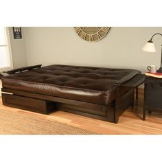 a living room with a couch, coffee table and lamp on the hardwood flooring