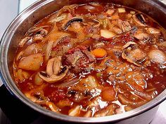 a pot filled with soup sitting on top of a stove