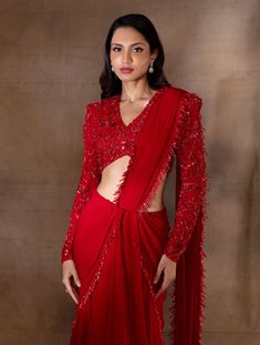 Red flowy skirt with an attached hip cowl drape, pleats & an attached pallu hand embellished with red pearl drops & glass bugles, paired with a power shoulder structured V neck full sleeve blouse featuring red floral hand embroidery.From Shloka Khialani's Winter Sun collection.DELIVERY TIMEPlease allow 6-8 weeks for your outfit to arrive.FABRIC DETAILSGeorgette, Net, CrepeProfessional cleaning only. Red Drape Saree, Full Sleeve V Neck Blouse Designs, Red Lehenga With Sheer Dupatta And Long Sleeves, Embellished Long Sleeve Pre-draped Saree For Party, Full Sleeves Blouse Designs Saree, Elegant Red Lehenga With Sequins, Elegant Long Sleeve Pre-draped Saree For Festive Occasions, Elegant Long Sleeve Pre-draped Festive Saree, Red Embellished Long Sleeve Gown