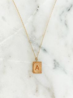 Experience the luxury of our 18k gold-plated stainless steel Initial Necklace! Free of lead and nickel, with a 16-inch chain and a 4-inch extender, you'll be stylishly adorned for any occasion. Minimalist Gold Stainless Steel Name Necklace, Trendy Gold Chain Necklace With Round Pendant, Gold Metal Initial Pendant Necklace, Gold Metal Pendant Initial Necklace, Square Pendant Initial Necklace Gift, Rectangular Pendant Initial Necklace With Adjustable Chain As Gift, Trendy Gold Name Necklace For Personalized Gift, Gold Locket Necklace With Adjustable Chain, Trendy Gold Charm Necklaces For Personalized Gift