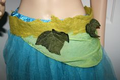 a mannequin wearing a green and blue dress with leaves on it's waist