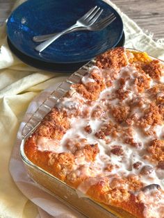 a casserole dish on a table with a fork and blue plate next to it