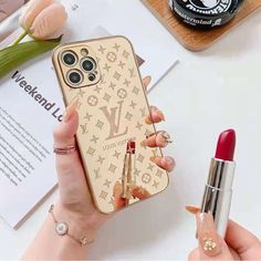 a woman is holding her phone case with lipstick on it and the cover has an image of louis vuitton