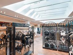 the inside of a clothing store with lots of items on display in cages and shelves