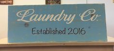 a blue sign that says laundry co established 2016 on top of a shelf in a kitchen