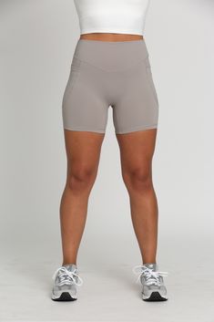 Level up your activewear with our Grey Mist V-Cut Shorts 5". The flattering V-Cut design at the waistband accentuates your curves and provides a secure fit. Buttery soft material with built-in pockets, these shorts are the perfect combo of comfort and functionality. Polyester / Spandex Blend V-Cut Waistband Built-In Side Pockets Model Details: Modeled in size: Medium Model Bust: 34 Model Waist: 30 Model Height: 5'6 Fitted Bottoms With Built-in Shorts For Light Exercise, Sporty Activewear With 5-inch Inseam And Side Pockets, Compressive Bottoms For Running With 5-inch Inseam, High Waist Bottoms With Built-in Shorts For Running, Gray Athleisure Activewear With Built-in Shorts, Gray Yoga Bottoms With Built-in Shorts, Gray Compression Bottoms With Built-in Shorts, Workout Activewear With 5-inch Inseam And Side Pockets, High Waist Activewear With Built-in Shorts