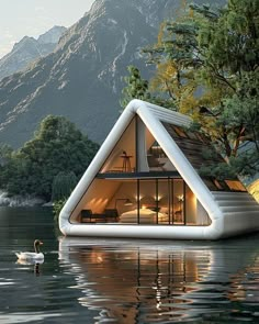 an unusual floating house in the middle of a lake with swans swimming around it and mountains in the background