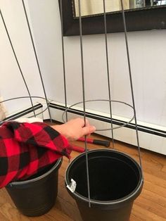 a boy is playing with some buckets on the floor