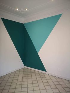 an empty room with green and white paint on the wall next to a tiled floor