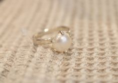 "Handmade sterling silver ring with a natural freshwater pearl. Dainty elegant ring, made by a jeweler with more than 25 years of jewelry design and creation experience. Please note, that each pearl is unique in its form, size, and color tone, therefore also each ring is unique and can slightly differ from the one in the pictures. If you would like to order the same design ring in bronze, gold-plated sterling silver, or 14-k gold, please, contact us! PRODUCT DETAILS -Diameter of the pearl: ca. 8 Sterling Silver Pearl Drop Ring In White Gold, Sterling Silver White Gold Pearl Ring With Pearl Drop, Handmade White Gold Pearl Ring For Formal Occasions, White Gold Pearl Drop Ring In Sterling Silver, White Gold Sterling Silver Rings With Pearl Drop, Sterling Silver Pearl Drop Ring For Promise, Sterling Silver Pearl Drop Ring For Promise Occasions, Fine Jewelry Sterling Silver Pearl Ring With Prong Setting, Sterling Silver Pearl Ring With Prong Setting