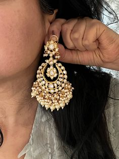 Discover a world of timeless beauty with our exquisite earrings collection. Each piece is a testament to the artistry and craftsmanship of our skilled artisans. Product Details: Material: Made of high-quality brass, Kundan Stones, Pearls, Gold Plating. Dimensions: Weight per Pair: 68 grams Length: 10 cm Width: 7 cm Closure Type: Push Back closure with Omega Clip at the back for extra support. Stand Out: Elevate your style with these unique, statement-making earrings that are bound to turn heads. Elegant Jhumkas For Ceremonial Festivals, Luxury Round Earrings For Ceremonial Occasions, Traditional Yellow Gold Chandelier Earrings For Formal Occasions, Luxury Meenakari Chandbali Jewelry, Classic Round Hand Set Earrings, Elegant Ceremonial Earrings, Hand Set Chandbali Earrings For Ceremonial, Hand Set Chandbali Earrings For Ceremonial Occasions, Luxury Chandbali Jewelry For Formal Occasions