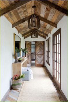 a hallway with wood paneling and wooden doors leading to another room in the house