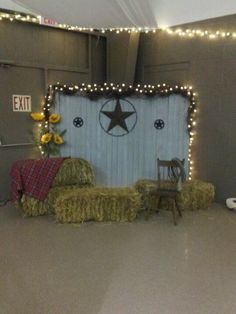 hay bales are stacked on top of each other in front of a barn door decorated with lights