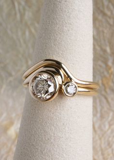 a gold ring with two diamonds on it