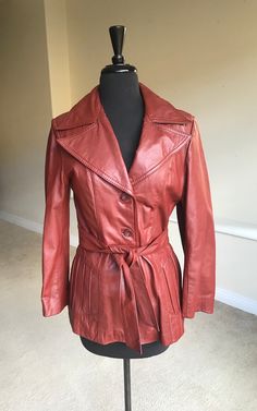 This is a vintage brown leather trench style jacket from the 1970s. This modern leather jacket or blazer is clean and in wonderful condition. The rust brown leather is supple, and in excellent condition, with no wear or marks. The lapels are large and cool, and the left lapel does tip up just a tad....a heavy book can fix that! This leather jacket has an attached belt and two lined pockets. The lining is perfectly clean, and has a fuzzy warm zip out liner that is perfect for the colder months! P Vintage Leather Jacket For Spring, Vintage Leather Outerwear For Fall, Retro Single-breasted Leather Jacket For Fall, Retro Brown Leather Jacket For Fall, Brown Leather Long Coat For Fall, Retro Single Breasted Leather Jacket, Retro Leather Jacket For Fall, Retro Leather Jacket For Formal Occasions In Fall, Retro Brown Leather Jacket For Work