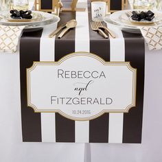 the table is set with black and white striped linens, gold accents, and place settings