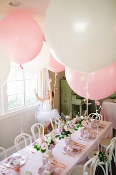 a table with pink and white balloons on it