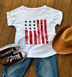 4th of July Womens Shirt. American Flag Top. Memorial Day Shirt. Graphic Tshirt. Country Music. USA shirt. All photos and designs are by Tanya Visconti of Rain Dancer Clothing Copyright 2015 All rights reserved The dolman rolled sleeve top has quickly become a favorite! Simple. Classy. Versatile. American. Pair it with your favorite boyfriend jeans, maxi shirt, or yoga pants. Throw it on over your bathing suit with flip flops and shorts for a 4th of July party. This top is PERFECT for throwing o Summer Flag Print T-shirt With Relaxed Fit, Cotton Crew Neck T-shirt With Flag Print, White Americana Letter Print T-shirt, Casual Crew Neck T-shirt With Flag Print, Americana Cotton T-shirt With Letter Print, White Cotton T-shirt With American Flag Print, American Style Pre-shrunk Short Sleeve Shirt, Summer Fan Merchandise Tops, Independence Day T-shirt With Sublimation Print