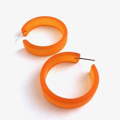 Orange frosted lucite hoop earrings in a straight & sturdy shape. This style is known as the 'Portland Hoop' (named after the maker's home in Portland, Maine) and comes in 2 sizes. The smaller of the 2 is called the "Chandler Hoop' and also comes in loads of colors. The Portland measures about 36mm or 1.5" in diameter & 10mm in width. One of our largest styles & yet it's still super light weight & easy to wear. Jewelry is designed & hand finished by us, here in the US. Most a Cheap Orange Statement Hoop Earrings, Cheap Orange Metal Earrings, Cheap Orange Dangle Hoop Earrings, Cheap Orange Hoop Earrings As A Gift, Cheap Orange Earrings, Cheap Orange Earrings For Spring, Cheap Retro Hoop Earrings For Pierced Ears, Unique Cheap Orange Earrings, Cheap Vibrant Orange Earrings