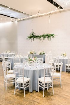 a room filled with tables and chairs covered in white linens