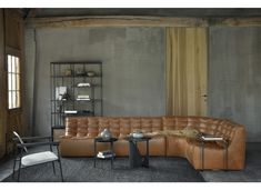 a living room filled with furniture next to a wall covered in bookshelves and shelves