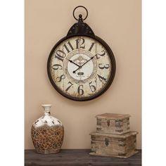 a clock is hanging on the wall next to a vase and other items in front of it