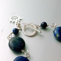 This lapis lazuli bracelet handcrafted by Jewelry By Carmal is made of navy blue lapis lazuli rondelle and disk gemstones, sterling silver: crown charm, toggle and findings. This bracelet measures up to 7 3/4 inches in length. View more beaded bracelets: http://www.etsy.com/shop/jewelrybycarmal?section_id=8002918 The ancient Romans used lapis as an aphrodisiac. Lapis lazuli is said to help stimulate emotional, mental, and physical purity and clarity. The ancient Egyptians used lapis for protecti Handmade Blue Sterling Silver Beaded Bracelets, Sapphire Lapis Lazuli Beaded Bracelet With Natural Stones, Handmade Sapphire Color Bracelets With Round Beads, Blue Sodalite Round Beaded Jewelry, Adjustable Artisan Lapis Lazuli Jewelry, Handmade Sodalite Round Bead Bracelets, Adjustable Beaded Bracelets With Toggle Clasp, Handmade Sodalite Round Bead Jewelry, Handmade Sodalite Jewelry With Round Beads