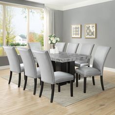 a dining room table and chairs in front of a window