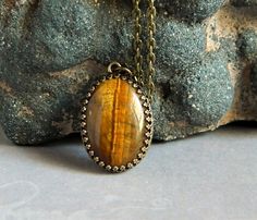 Tiger Eye Pendant Brown Statement Tiger Eye by MsBsDesigns on Etsy Brown Oval Gemstone Jewelry, Spiritual Brown Oval Pendant Jewelry, Brown Cabochon Pendant Jewelry, Oval Cabochon Brass Necklace, Antique Oval Necklace With Natural Stones, Brown Oval Spiritual Necklaces, Bronze Cabochon Round Pendant Jewelry, Bronze Round Cabochon Pendant Jewelry, Brown Oval Natural Stone Necklace