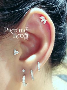 a woman's ear with three piercings on it