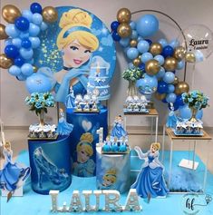 a table topped with lots of blue and gold balloons next to a sign that says latira