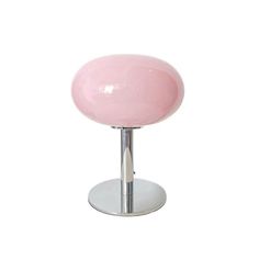 a pink table lamp sitting on top of a metal base