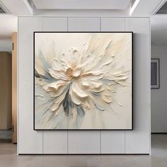 a large white flower painting hanging on the wall in an office lobby with tile flooring