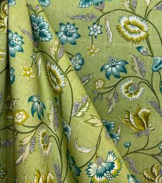 a green floral print fabric with blue and yellow flowers on the bottom half of it