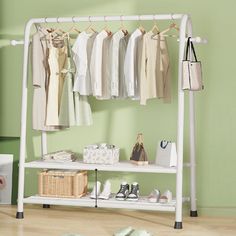 a white rack with clothes and shoes on it in a green room next to a wall