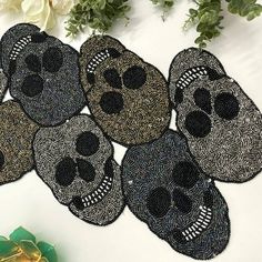 six black and white skull rugs on top of a table next to some flowers