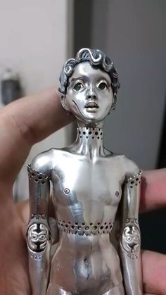 a person holding a silver statue in their hand