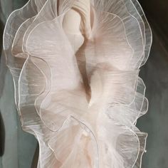 a woman's white dress with ruffles on it