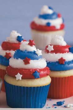 three cupcakes with red, white and blue frosting on them sitting on a plate