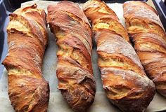 four loaves of bread sitting on top of a pan