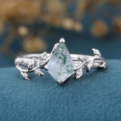 a close up of a ring with leaves on it and a stone in the middle