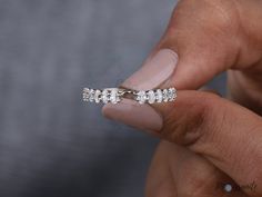 a woman's hand holding a diamond ring