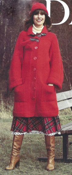 a woman standing in front of a bench wearing a red coat and plaid skirt