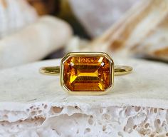 This beautiful ring contains a natural 2.00 ct. emerald cut yellow citrine. The ring is available in sterling silver, and 14K white, yellow or rose gold. The mounting is a modern, high polish, heavyweight setting. The center stone measures 8x6mm. This ring makes a great gift for a birthday, Mother's Day, bridesmaids, or any other special occasion. Yellow Citrine is the birthstone for November. Please send me a message if you need a size not listed. This ring can be customized with any color cent Yellow Emerald-cut Topaz Ring, Emerald Cut Topaz Ring With Bezel Setting As Gift, Yellow Gold Citrine Topaz Ring, Emerald Cut, Emerald Cut Yellow Gold Topaz Ring With Bezel Setting, Emerald-cut Yellow Gold Topaz Ring With Bezel Setting, Orange Emerald Cut Jewelry For Anniversary, Emerald Cut Yellow Gold Topaz Ring, Citrine Rings With Bezel Setting, Citrine Gemstone Rings In Baguette Cut