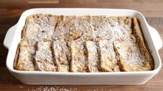 a casserole dish with powdered sugar on the top and bottom, sitting on a wooden table